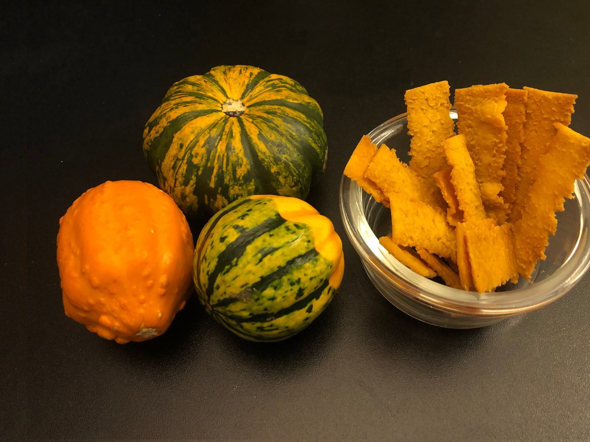 Pumpkin Paprika rice chips styled with autumn pumpkins and leaves